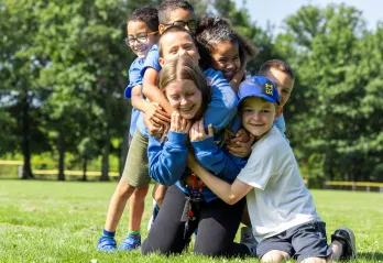 Kids hugging a counsellor at camp