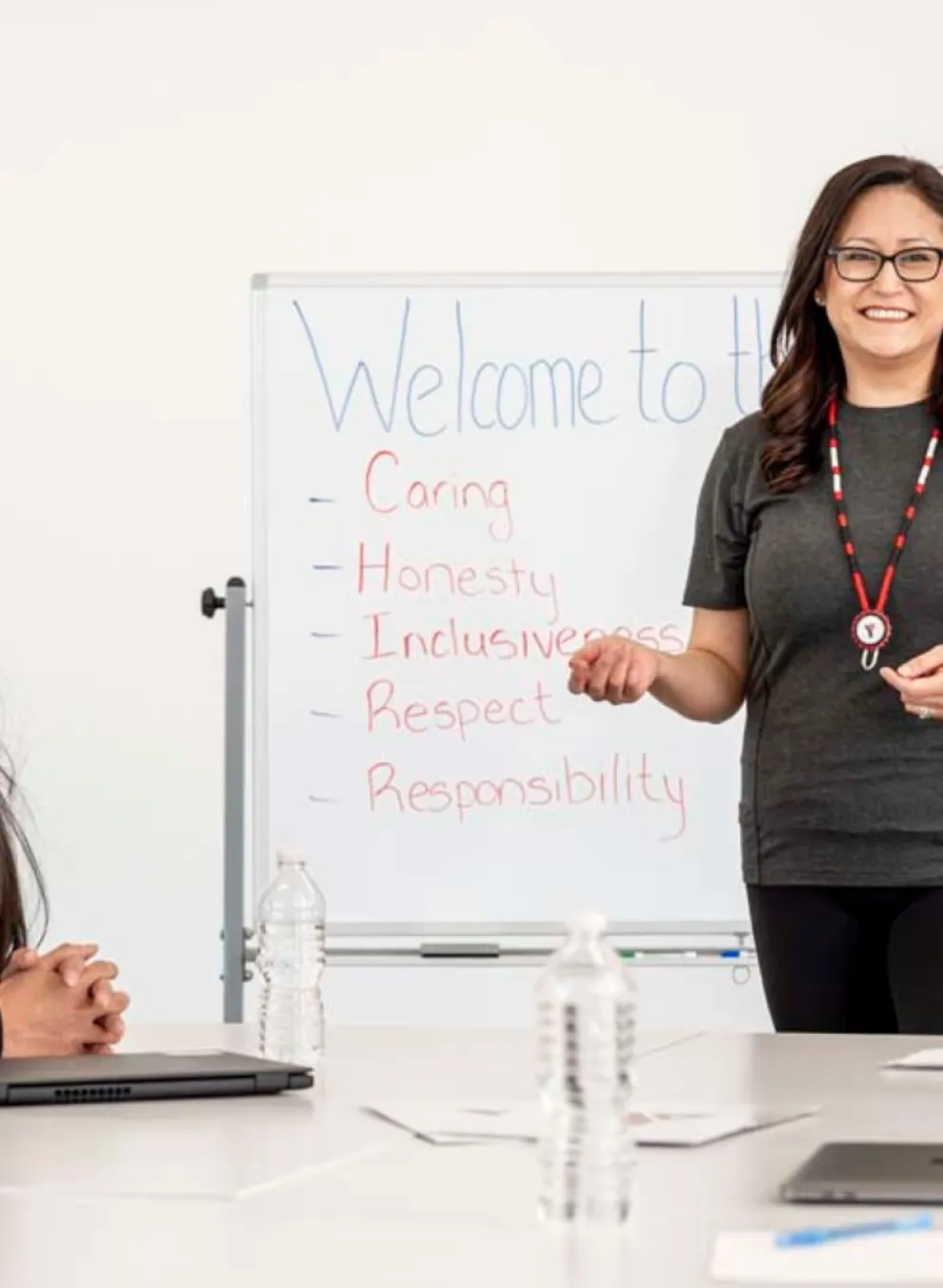 An employment specialist leads a training session with program participants in front of a white board.