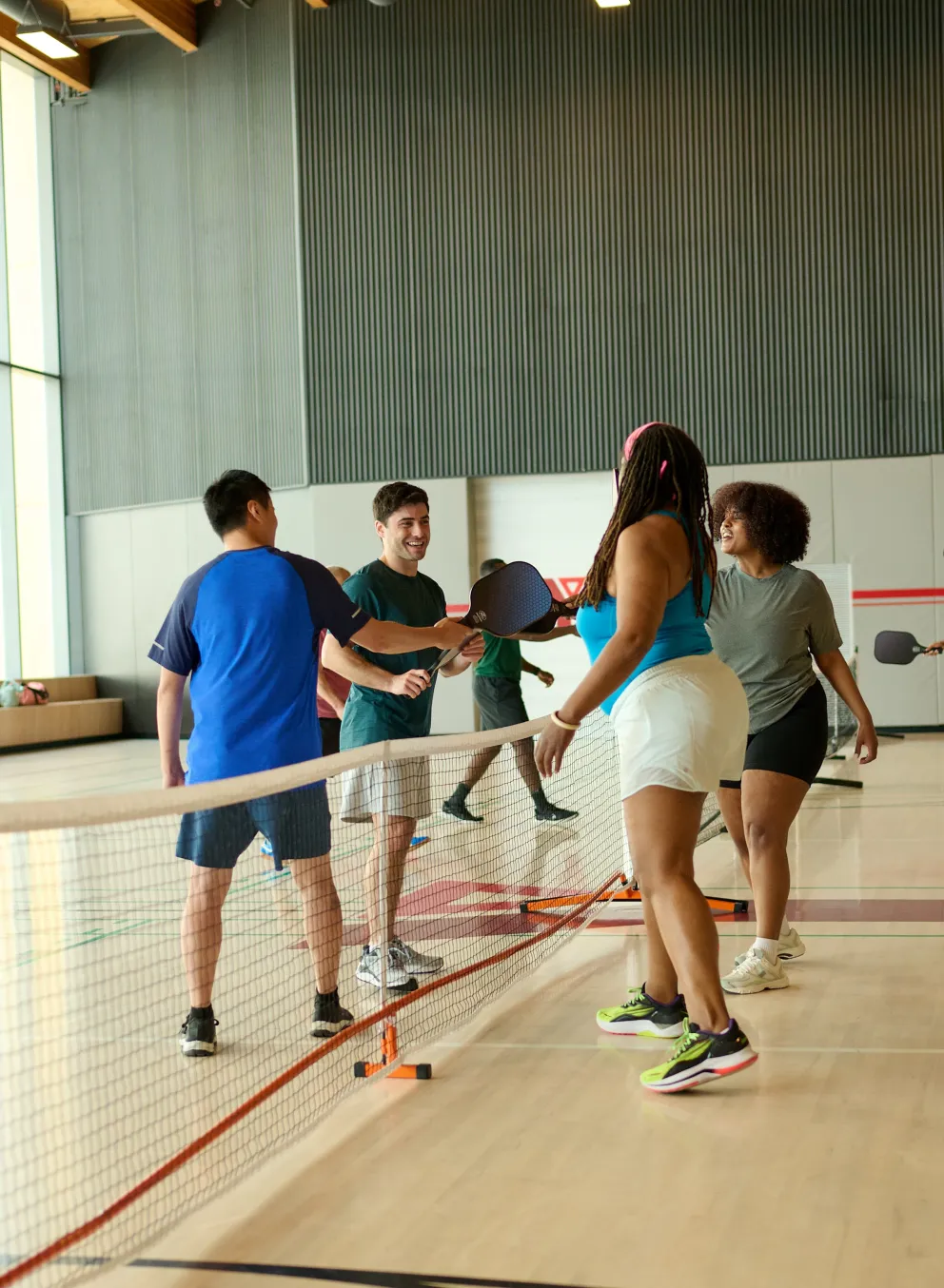 Four adults playing pickleball