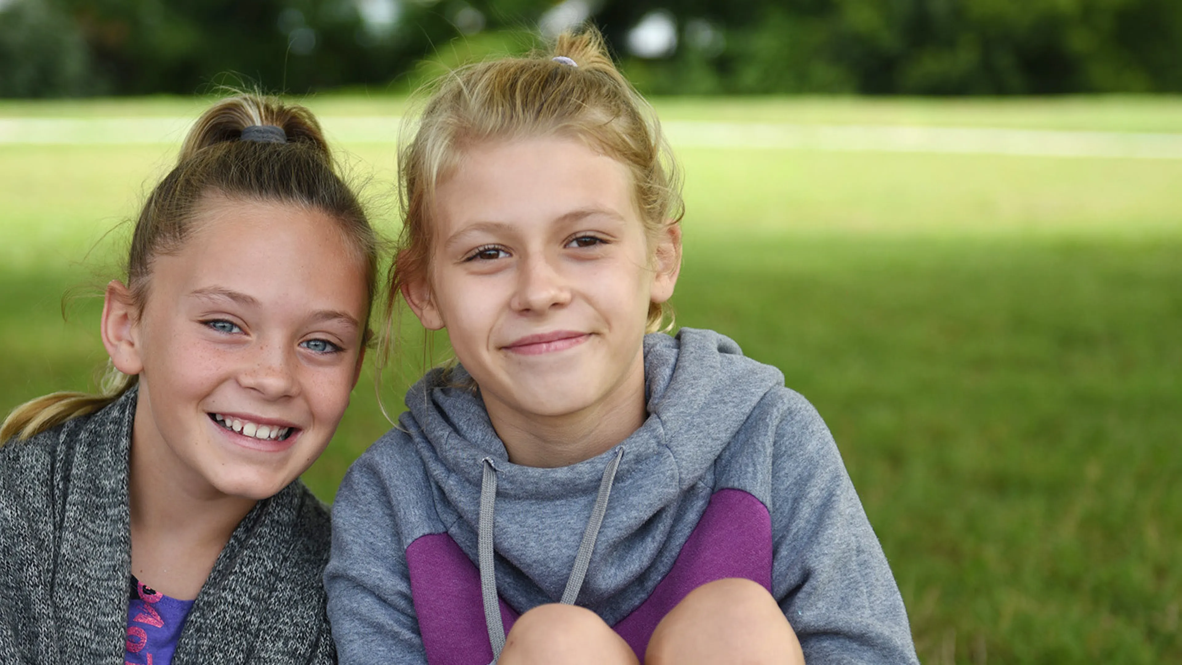 Two girls sitting on the grass at Camp