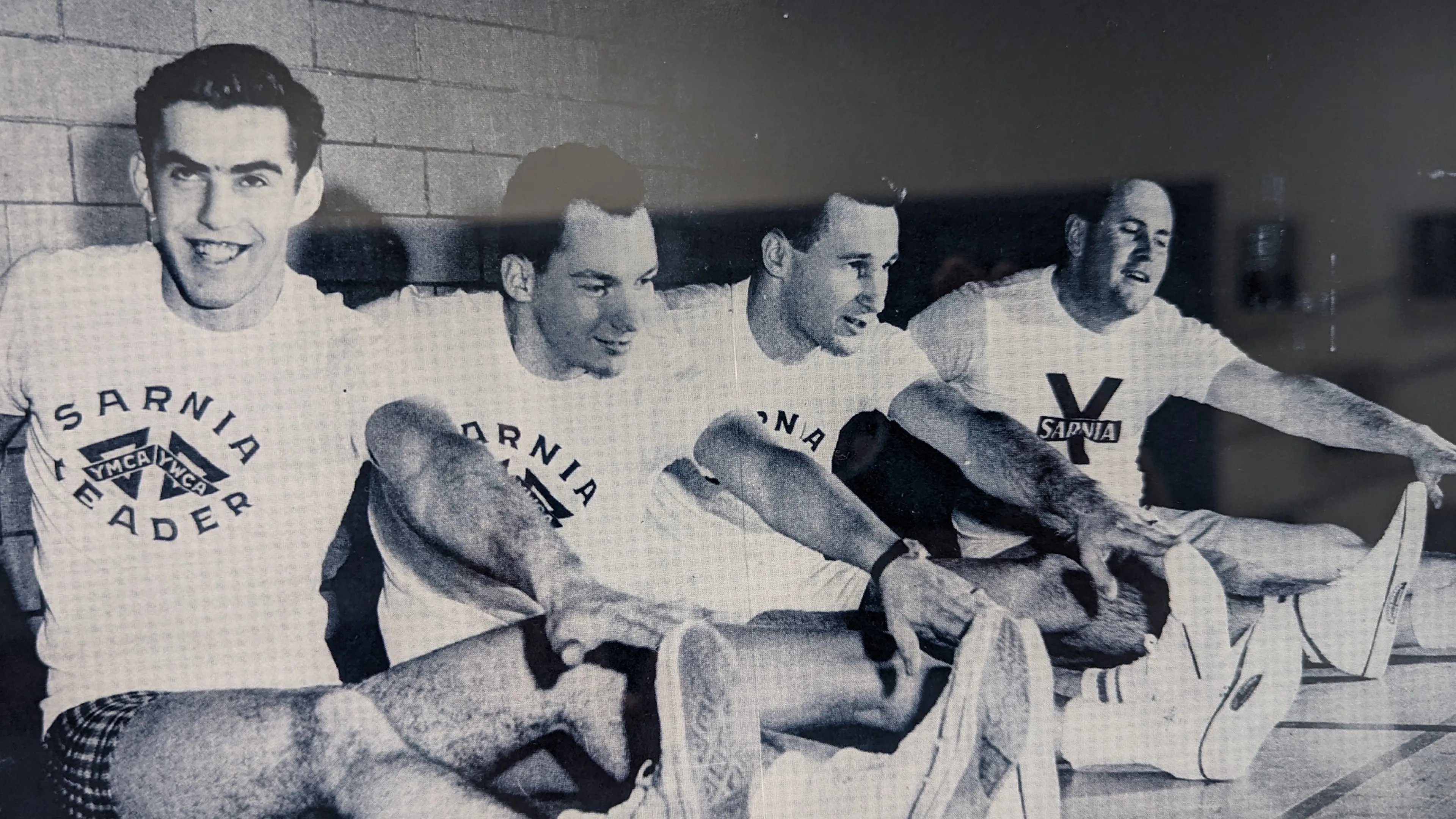 Four men streatching in historic photo
