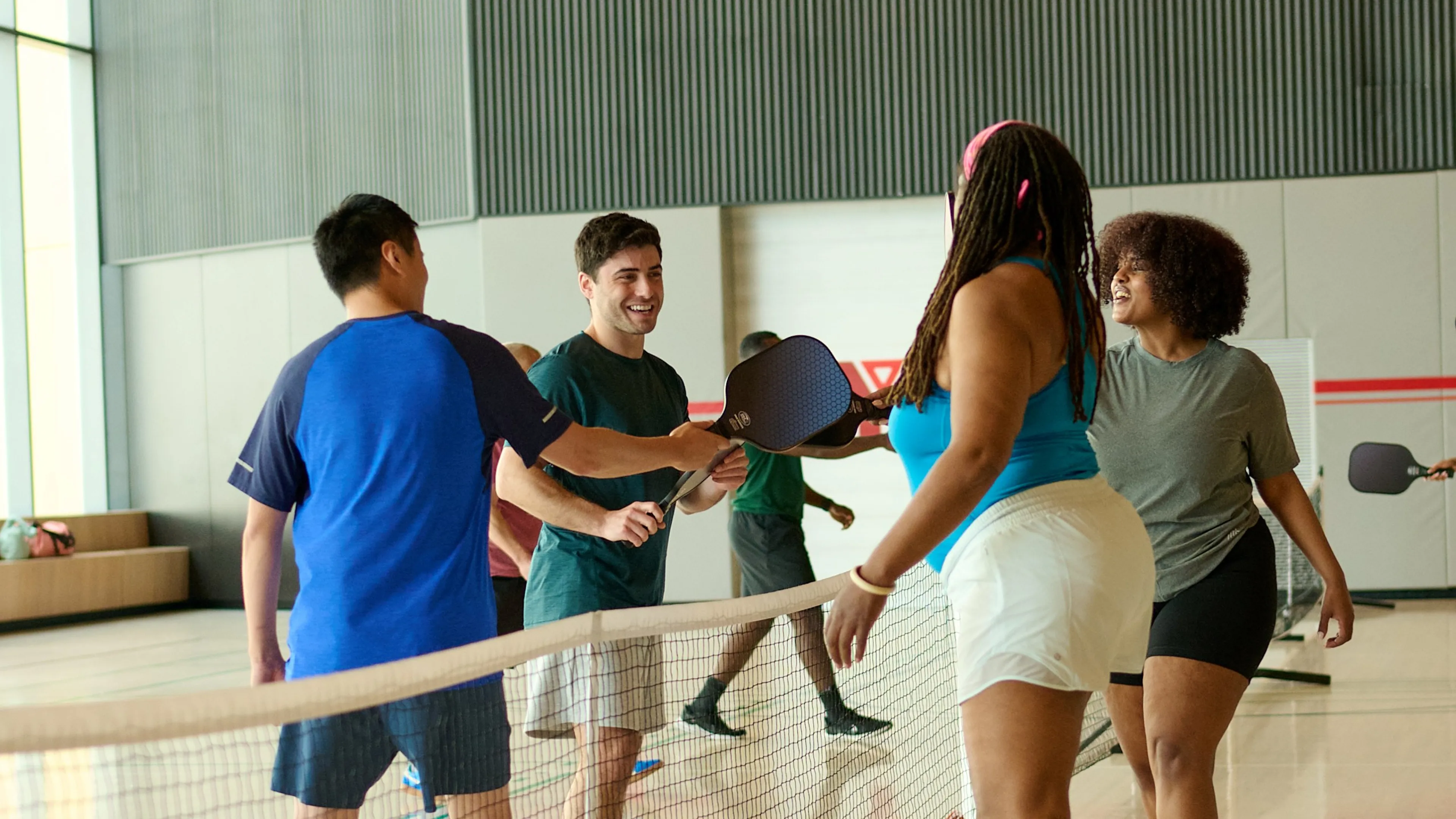 Four adults playing pickleball
