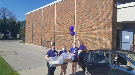 Four &quot;Purple Shirt&quot; camp staff pack up camp kits to deliver to families outside the YLCC.