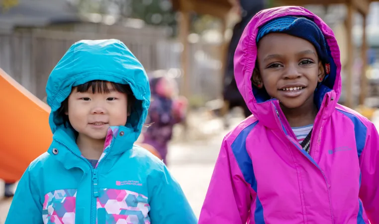 Two smiling girls playing outside 