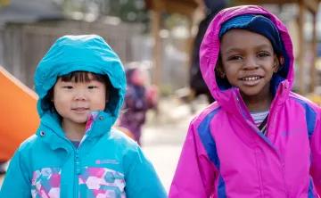 Two smiling girls playing outside 