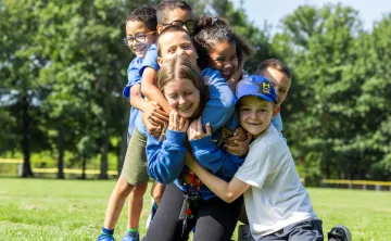 Kids hugging a counsellor at camp